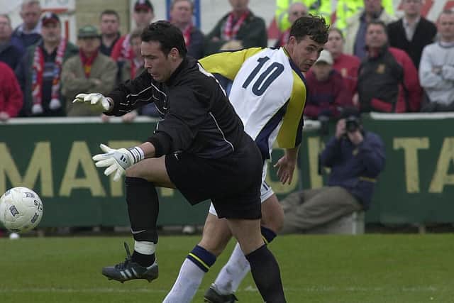 James Taylor tangles with Tamworth goalkeeper Darren Acton during Hawks' FA Trophy semi-final second leg in 2003.