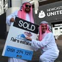 Newcastle United supporters dressed in robes pose with 'sold' placards as they celebrate the sale of the club to a Saudi-led consortium, outside the club's stadium at St James' Park, on October 8, 2021.
Photo by Oli Scarff/AFP via Getty Images