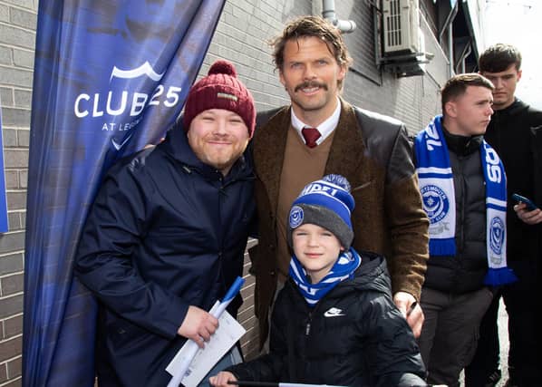 The Hermannator, Hermann Hreidarsson, poses with fans ahead of the game.