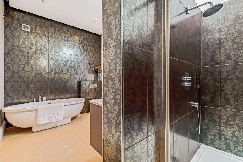 The generously-proportioned master en-suite bathroom features a free standing bath, large shower enclosure and a double vanity sink unit.
