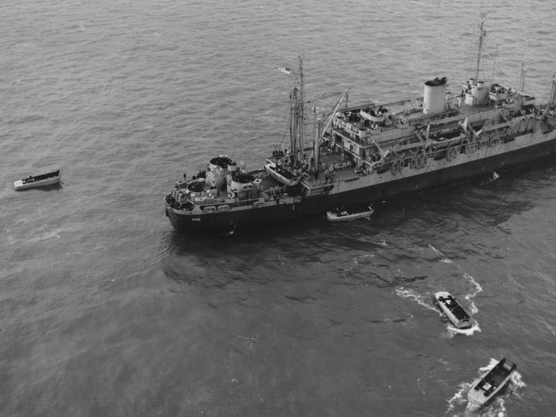 An assault transport ship with LCVPs [Landing Craft, Vehicle, Personnel]. Possibly during training exercises but similar scenes would have been seen on D-Day. The ship carried the LCVPs on davits on its sides, then anchored off the landing beach so the LCVPs could land the troops on board.