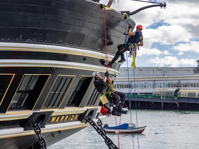 Firefighters practicing rescue from the sea, ascending by rope onto HMS Warrior during the UKRO event at Portsmouth Historic Dockyard. Picture: Mike Cooter (280924)