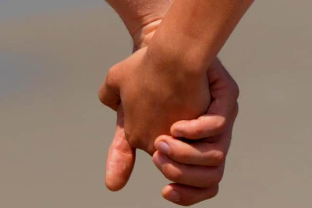 Students holding hands on campus.