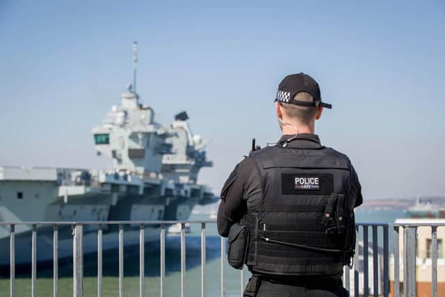 HMS Prince of Wales returns to Portsmouth on March 25, with a police officer watching the ship's arrival. 
Picture: Habibur Rahman