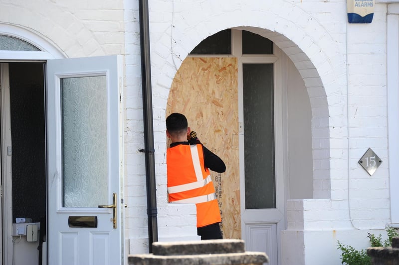 Workers board up houses that have been affected by the late night fire.