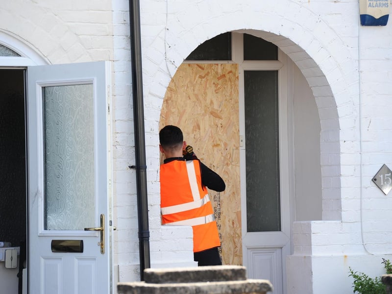 Workers board up houses that have been affected by the late night fire.