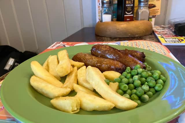 A children's sausage, chips and peas
