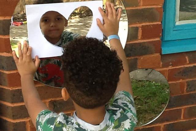 Evan Ayantoye, six, helps to make one of the sensory mirrors.