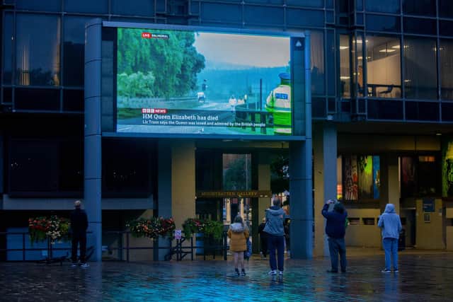 People watching the the news on the big screen at  Portsmouth Guildhall after the announcement of the Queen's death
Picture: Habibur Rahman