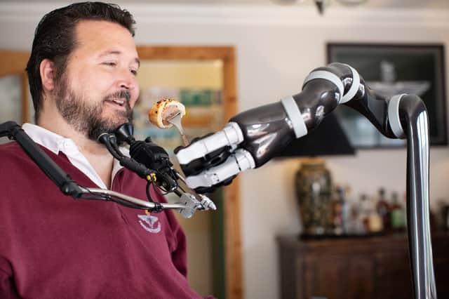 Military veteran Jon Noble from Havant, Hampshire has able to feed himself for the first time in 17 years in July, after receiving a robotic arm thanks to charity funding. Jon has become the first person with a spinal cord injury in the UK to receive a JACO assistive robotic arm. Picture: Andy Bate.