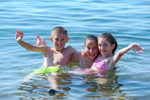 From left, Logan, 10, Yazmin, 12, and Ellie, 7, in the water off the Hotwalls, Old Portsmouth