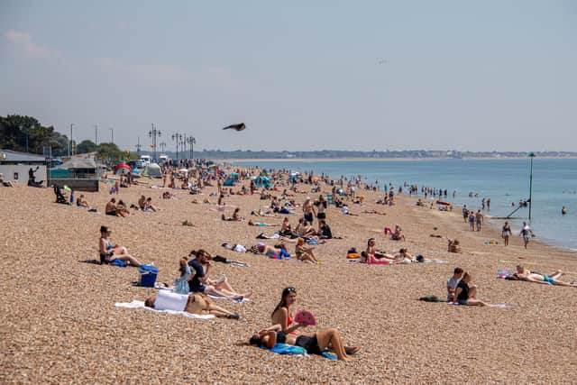 Pictured: People enjoying the sunshine on the beach
