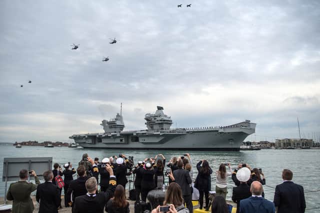 Helicopters and jets from the Royal Navy and Royal Air Force perform a fly-past as HMS Queen Elizabeth sails into her home port of Portsmouth Naval Base on August 16, 2017 for the first time. Photo by Carl Court/Getty Images.