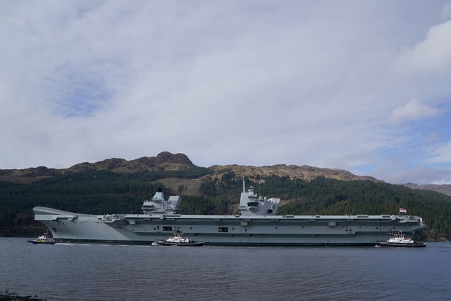 The Royal Navy aircraft carrier HMS Queen Elizabeth leaving Glen Mallan in Loch Long with the Arrochar Alps behind.