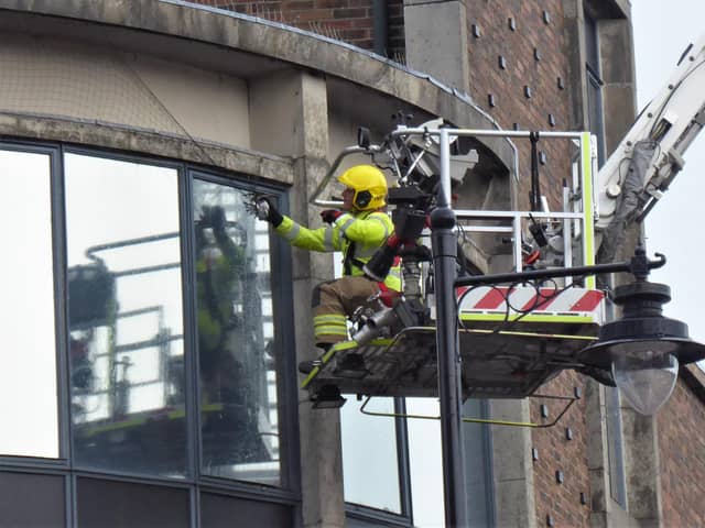 Southsea firefighter Max Hewett rescues a pigeon trapped by netting around the Knight and Lee building near Palmerston Road.