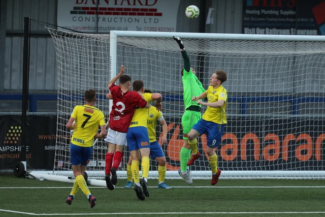 Hawks goalkeeper Mackenzie Moore tips the ball away from Camberley's Kai Hobbs. Picture by Dave Haines.