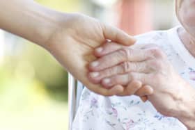 A woman holding hands with a carer.