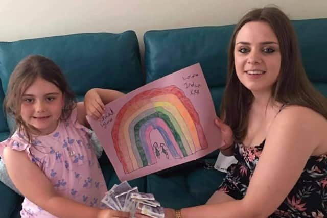 India-Rose presenting the cash from her paramedic appeal to family friend Louise Solomon