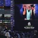 A photo of Elton John and Shane Warne is projected onto a screen during a memorial service for Warne at the Melbourne Cricket Ground in Melbourne. AP Photo/Asanka Brendon Ratnayake)