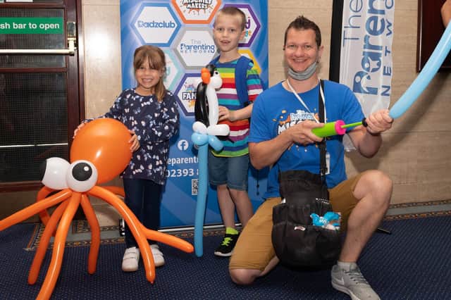 Pictured is: Katie and Charlie Hannant with Dan Churchly, balloon sculpture. Picture: Keith Woodland (140821-40)