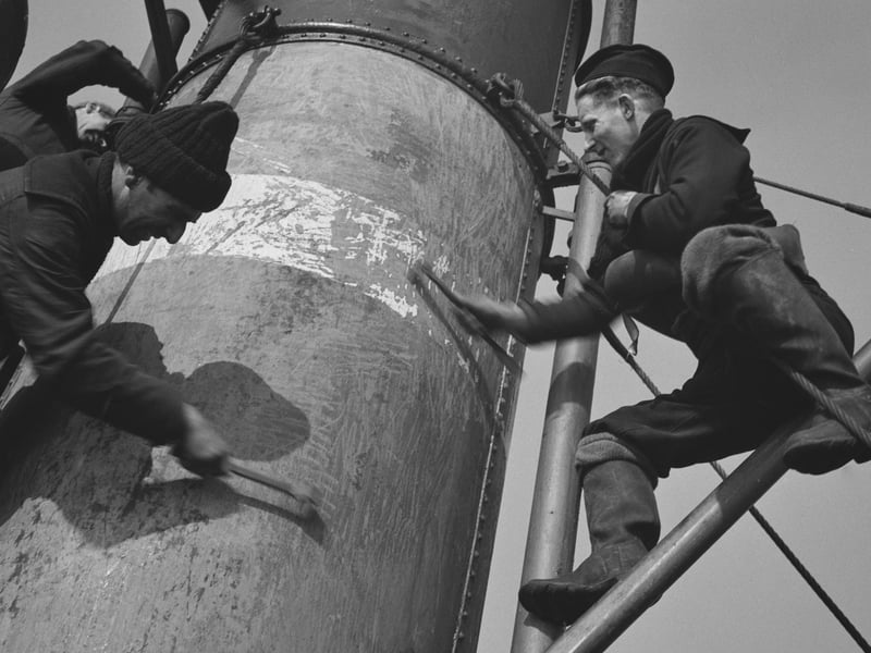 Crew members working on the funnel of a Royal Navy minesweeper during World War II, March 1941.  (Photo by Horace Abrahams/Keystone Features/Hulton Archive/Getty Images)