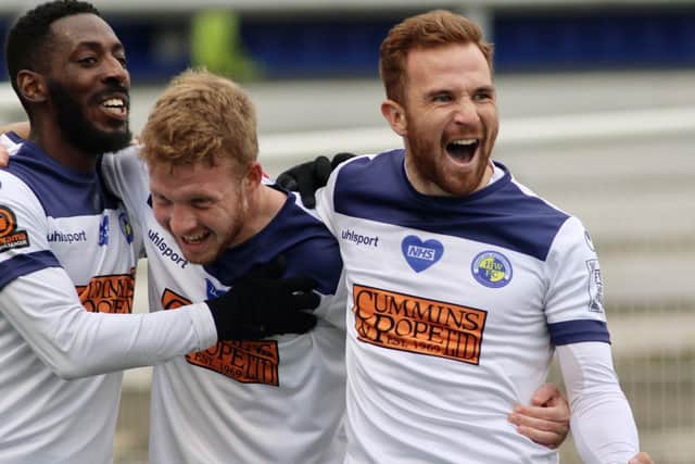 Roarie Deacon, Tommy Wright and Theo Widdrington celebrate Hawks' late winner at Billericay. Pic: Kieron Louloudis.