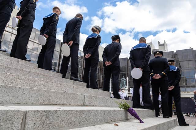 Heads bowed and flowers offered on the Guildhall steps. Picture: Mike Cooter (180922)