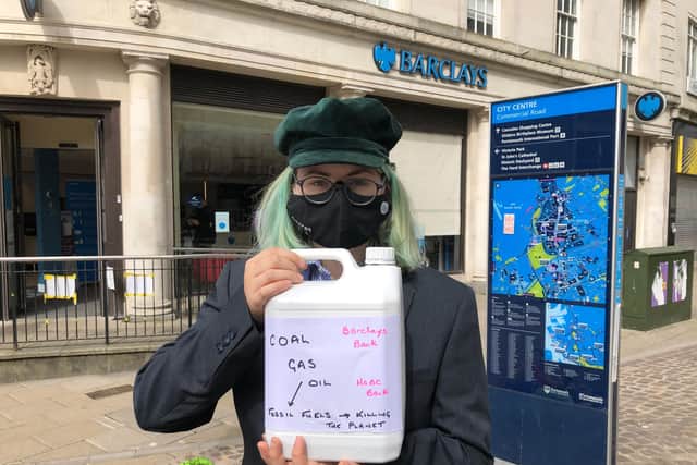 Extinction Rebellion activist Selma Heimedinger before dumping fake oil into a children's paddling pool in front of the Barclays branch in Commercial Road. Picture: Richard Lemmer