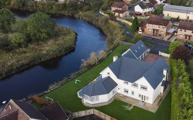 The property sits on a large plot next to the River Carron.