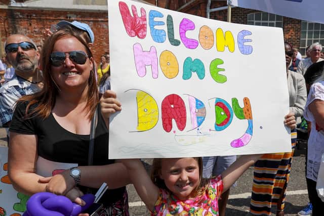 Emma Hall holding up her sign to welcome her dad home on board HMS Duncan after more than six months on deployment to the Mediterranean, Aegean and Black Sea.
Photo: Barry Swainsbury/Royal Navy