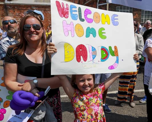 Emma Hall holding up her sign to welcome her dad home on board HMS Duncan after more than six months on deployment to the Mediterranean, Aegean and Black Sea.
Photo: Barry Swainsbury/Royal Navy
