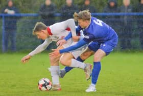 Horndean goalscorer Zack Willett, left, holds off a Baffins opponent in the rain. Picture by Martyn White