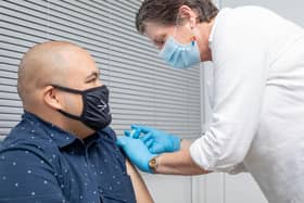 Booster vaccines being given at Goldchem Pharmacy, Albert Rd, Portsmouth on Wednesday 15th December 2021. Registered nurse,Kate Finch giving a booster jab to Adrian Ulanimo. Picture: Habibur Rahman