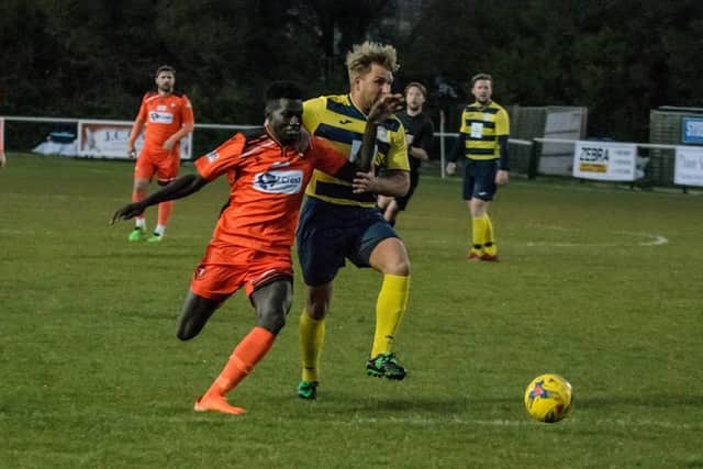 New Portchester signing Lamin Jatta (orange) in action against Paulsgrove's Billy Butcher. Pic: Daniel Haswell.