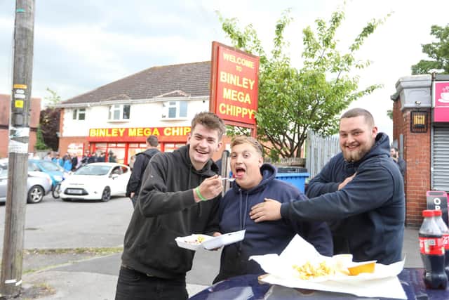 From left, Jake, Tom and Josh from Portsmouth eating their chips outside Binley Mega Chippy in Coventry Picture: SWNS