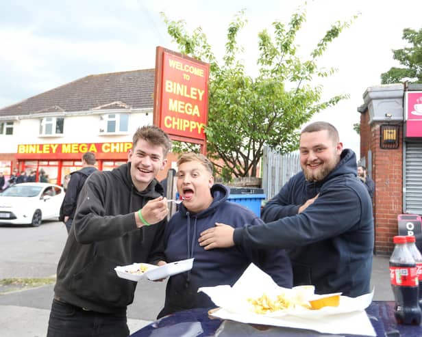 From left, Jake, Tom and Josh from Portsmouth eating their chips outside Binley Mega Chippy in Coventry Picture: SWNS