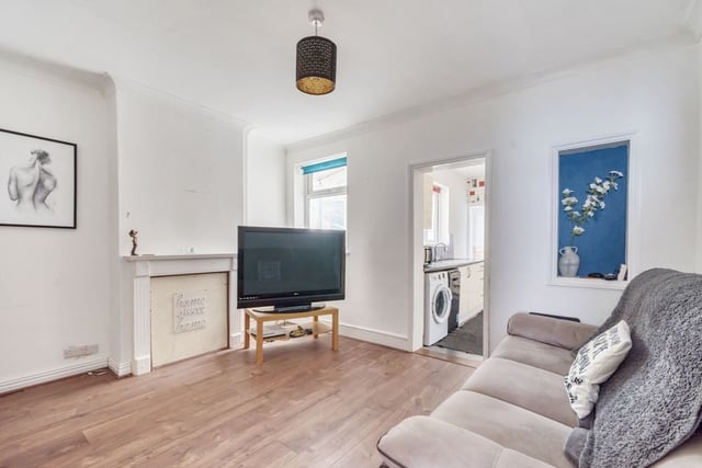 The living room goes into a large, modern kitchen space.