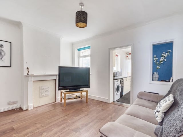 The living room goes into a large, modern kitchen space.
