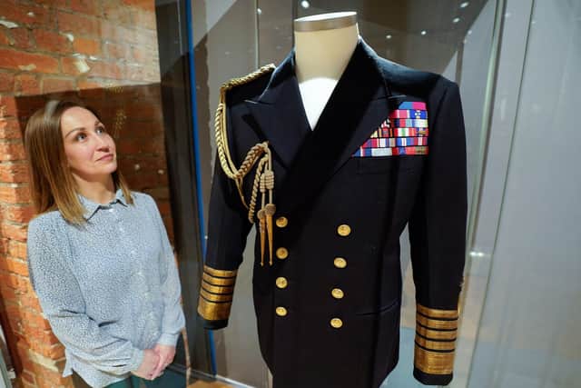 Kate Braun, curator at the National Museum of the Royal Navy, looks at a naval uniform which once belonged to the Duke of Edinburgh as it goes on display at the "Her Majesty's Service, The Queen's role at the heart of the Royal Navy family" exhibition at the National Museum Of The Royal Navy, Portsmouth Historic Dockyard. Picture: Andrew Matthews/PA Wire