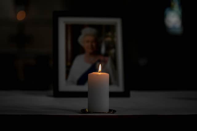 A candle lit in front of a picture of Her Majesty the Queen at Portsmouth Cathedral 
Picture: Habibur Rahman