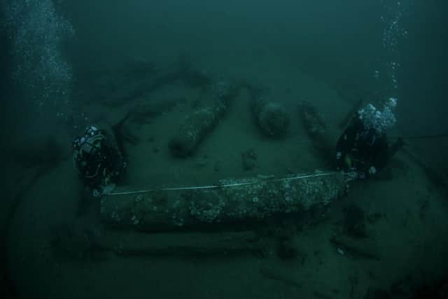 Julian and Lincoln Barnwell measuring a cannon that was found with the wreck. Picture: Norfolk Historic Shipwrecks/PA Wire