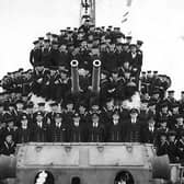 Crew member of HMS Lapwing. Here we see the officers and men of the ship gathered around A & B turrets.  