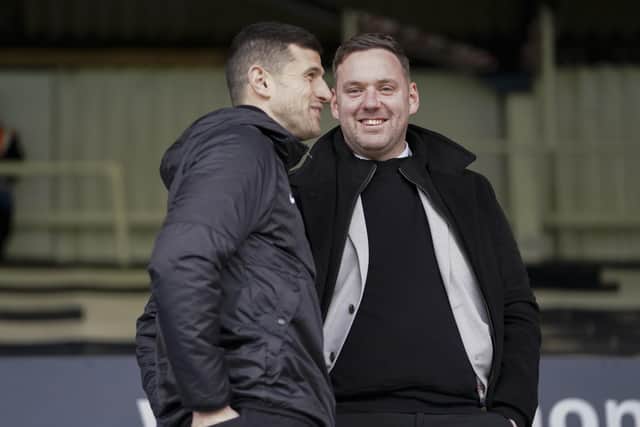 John Mousinho in discussion with sporting director Rich Hughes before Saturday's game at Peterborough