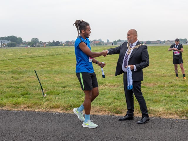 Councillor Fred Birkett (Mayor of Fareham) presents a medal to a participant of the Run The Runway event.
Picture: Mike Cooter