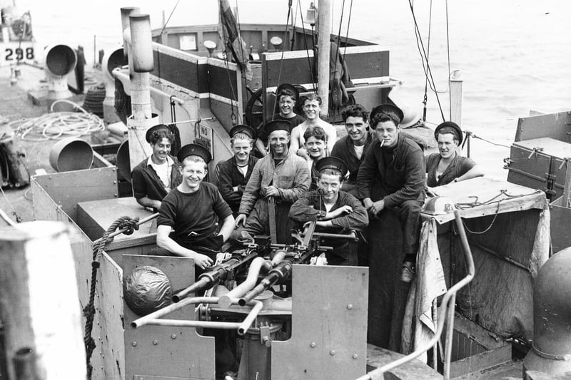 Some of the crew of an LCI(L) or Landing Craft, Infantry (Large), gathered behind one of its twin Oerlikon guns.
