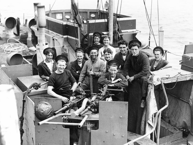 Some of the crew of an LCI(L) or Landing Craft, Infantry (Large), gathered behind one of its twin Oerlikon guns.