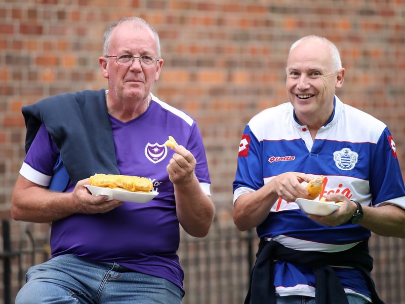 A Pompey fan and a QPR supporter enjoy some pre match food prior to the League Cup tie at Loftus Road in August 2019. Photo by Alex Pantling/Getty Images