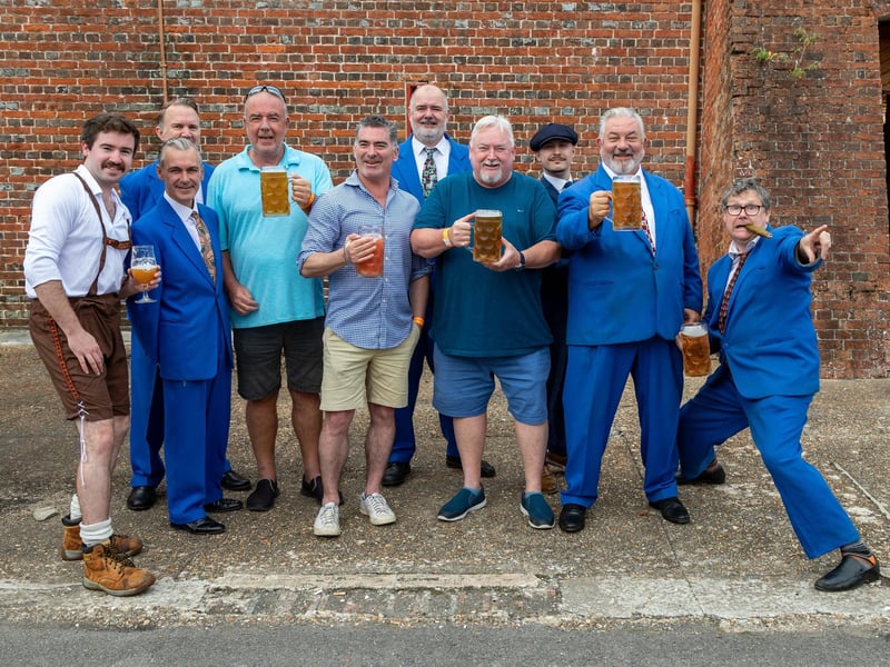 Organisers and entertainers at the Oktoberfest. Pictured: Andy Burdon (blue shorts - CEO of Powder Monkey Group) with Mike McGeever (dark grey shorts - Chairman of Powder Monkey Group) and Ben Twomey (beige shorts - CEO of Southern Highlands Brewery, Australia) with members of the band 'King Pleasure and The Biscuit Boys'. Picture: Mike Cooter (011023)