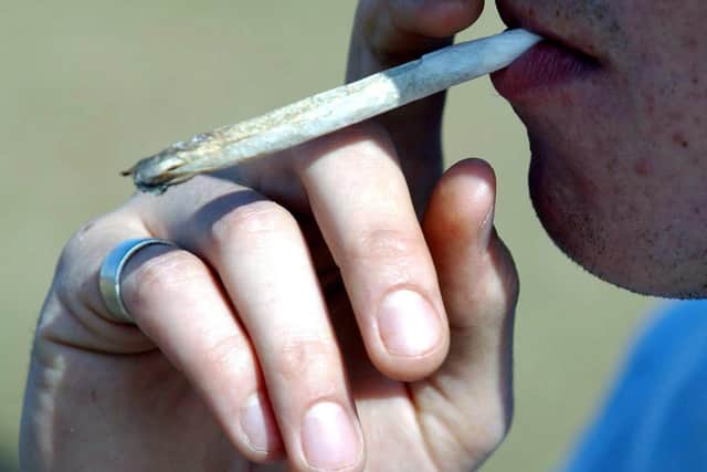 A man smoking a cannabis joint.