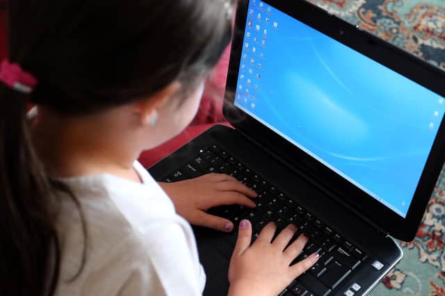Child using a laptop computer. PA Images